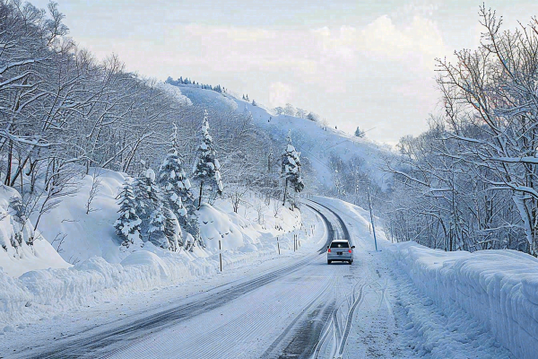 冬天雪山山区公路行驶的汽车白雪覆盖寒冷摄影图