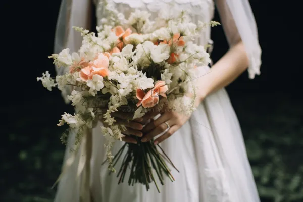 拿手捧花新娘白色婚纱森林婚礼摄影图