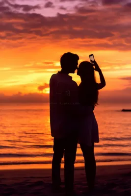 夕阳落日海边的情侣拍照唯美晚霞摄影图