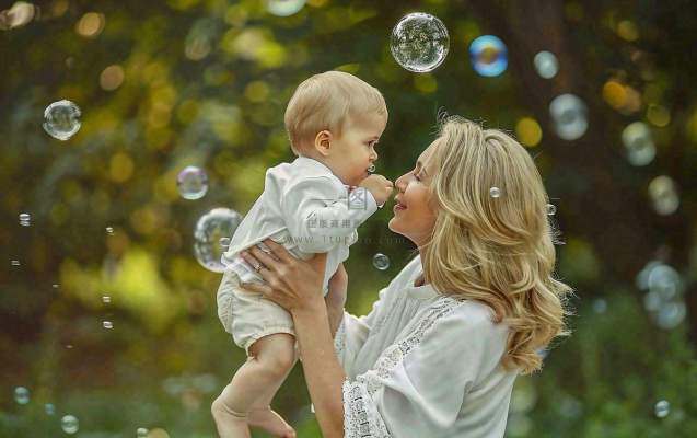 妈妈抱着孩子公园泡泡温馨母亲节摄影图