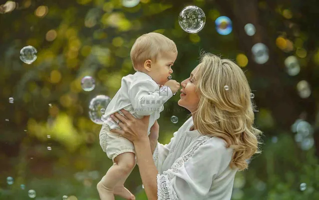 妈妈抱着孩子公园泡泡温馨母亲节摄影图