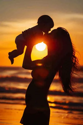 母亲节晚霞妈妈抱孩子温馨摄影图