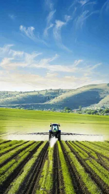 农田庄稼里耕种的机器农忙劳动节摄影图