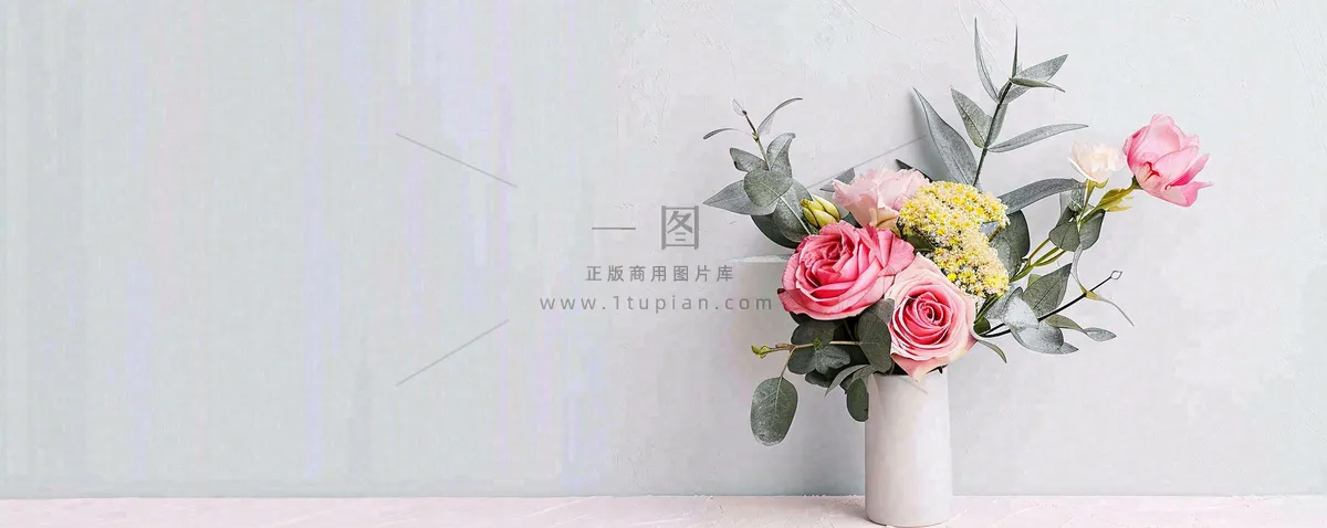 简约的墙面前有一瓶鲜花花束绿植,鲜艳清新新鲜室内装饰摄影图