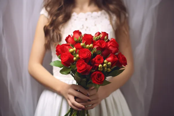 穿着白婚纱的新娘红色玫瑰花手捧花摄影图