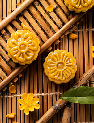 中国传统糕点月饼竹制托盘上的月饼中秋节木制背景摄影图