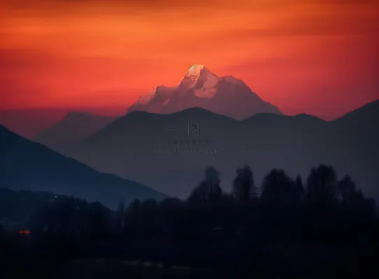 傍晚高原的山峰被落日照亮，日照金山风格摄影图