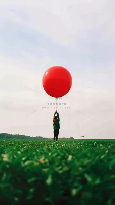 草地天空中的红色气球愚人节摄影图