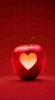 红色苹果掏爱心形状创意平安夜摄影图