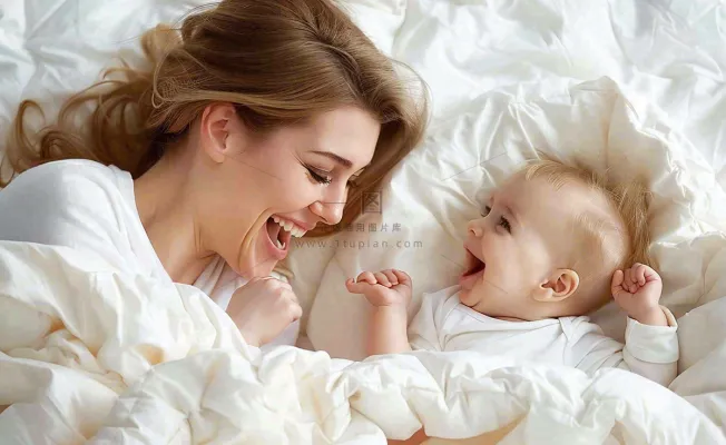 妈妈陪着婴儿玩耍白色床温馨母亲节摄影图