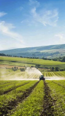农田庄稼里耕种的机器农忙劳动节摄影图