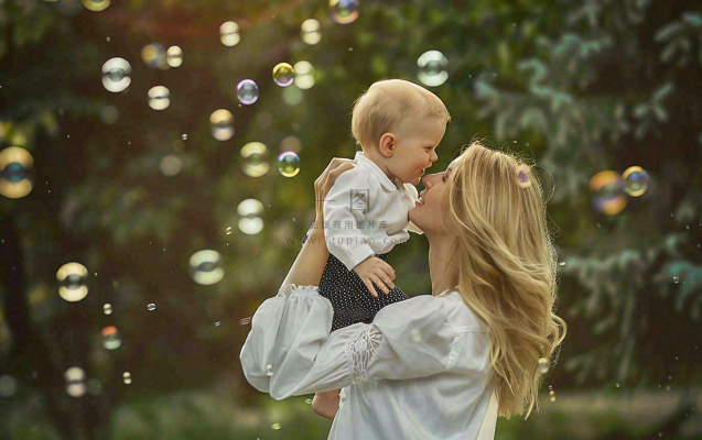 妈妈抱着孩子公园泡泡温馨母亲节摄影图