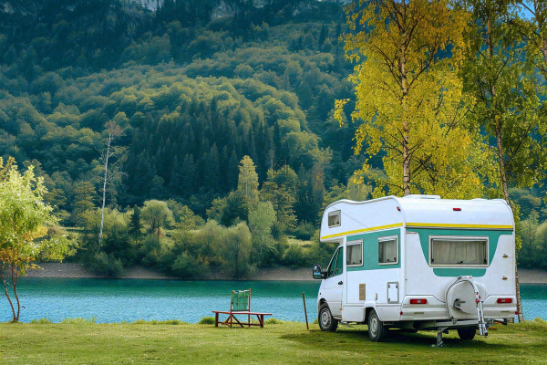 野外露营湖边停着一辆房车，野餐，春游摄影图