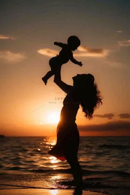 母亲节晚霞妈妈抱孩子温馨摄影图