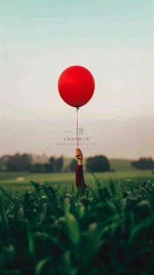 草地天空中的红色气球愚人节摄影图