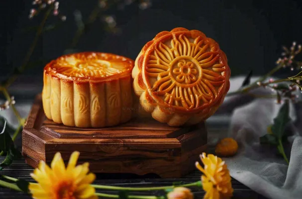 中国传统美食月饼中秋节菊花摆盘黑色背景摄影图