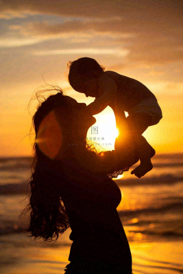 母亲节晚霞妈妈抱孩子温馨摄影图