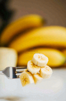 香蕉刀叉插着的香蕉片水果摄影图