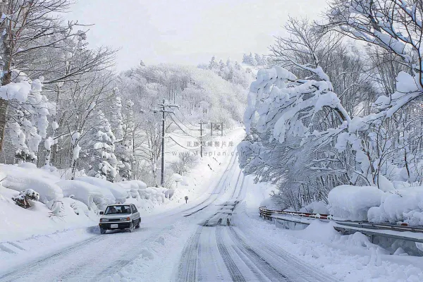 冬天雪山山区公路行驶的汽车白雪覆盖寒冷摄影图