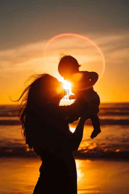 母亲节晚霞妈妈抱孩子温馨摄影图