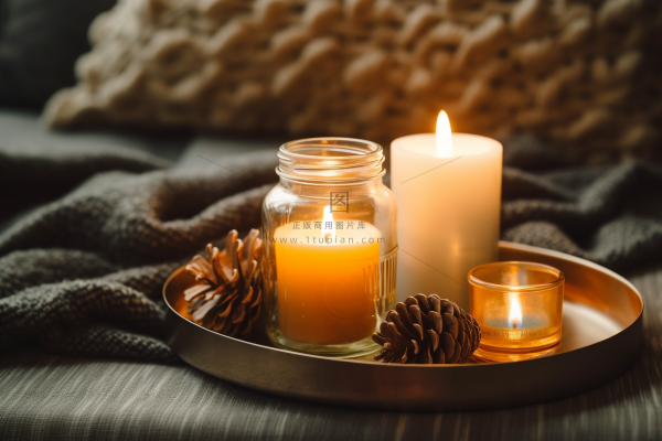 秋冬房间茶几托盘里点燃的香薰杯蜡烛松果玻璃瓶摄影图