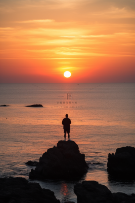 站在礁石上观赏落日的人落日余晖倒影摄影图