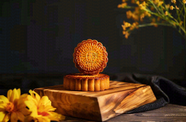 中国传统美食月饼中秋节菊花摆盘黑色背景摄影图