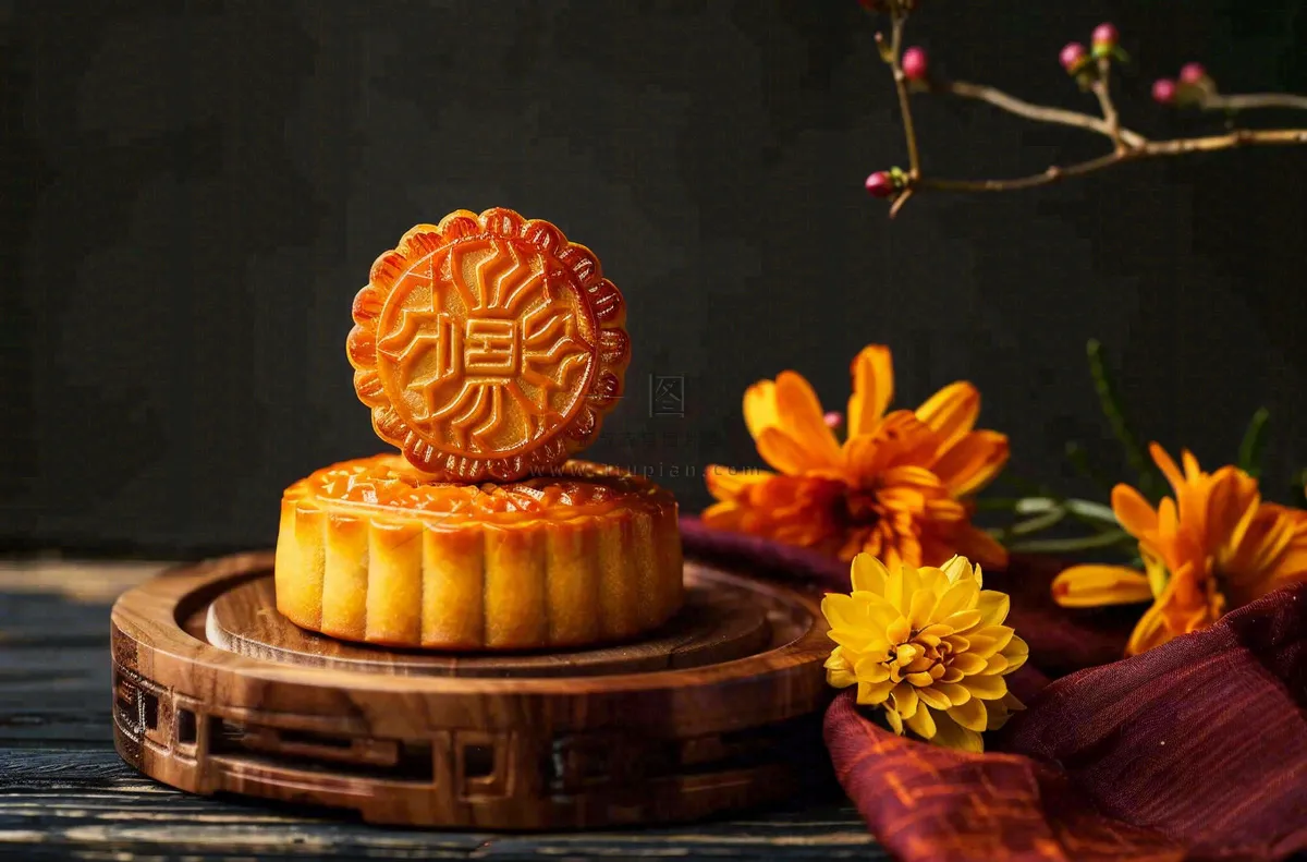 中国传统美食月饼中秋节菊花摆盘黑色背景摄影图