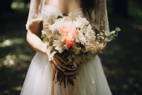 拿手捧花新娘白色婚纱森林婚礼摄影图