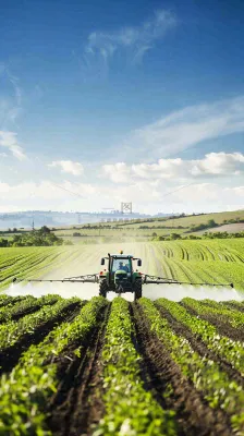 农田庄稼里耕种的机器农忙劳动节摄影图