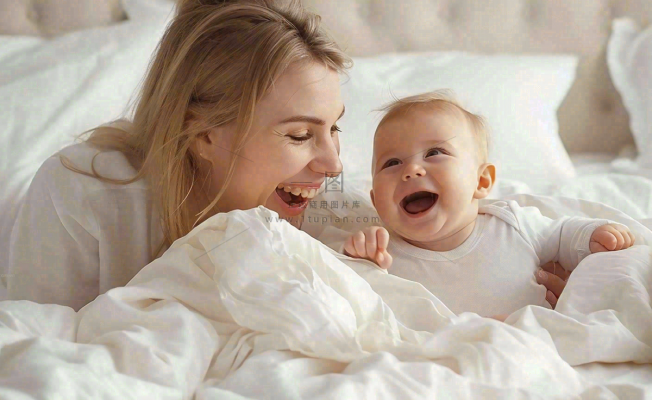 妈妈陪着婴儿玩耍白色床温馨母亲节摄影图