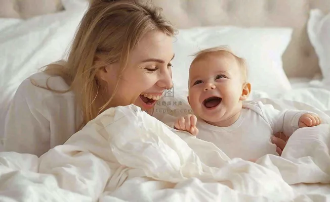 妈妈陪着婴儿玩耍白色床温馨母亲节摄影图