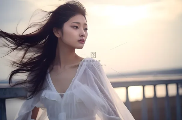 一个美女穿着一件漂亮的白色连衣裙在海边的拍照摄影图