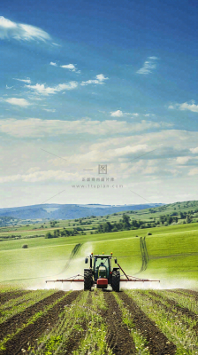 农田庄稼里耕种的机器农忙劳动节摄影图