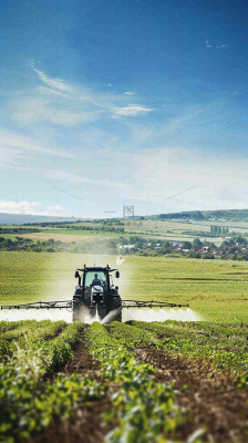 农田庄稼里耕种的机器农忙劳动节摄影图