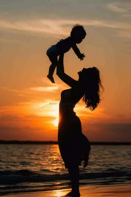 母亲节晚霞妈妈抱孩子温馨摄影图