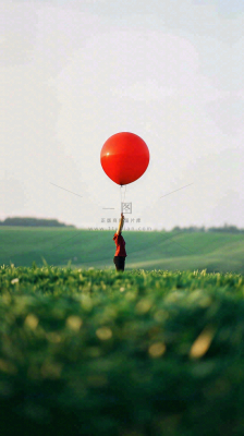 草地天空中的红色气球愚人节摄影图