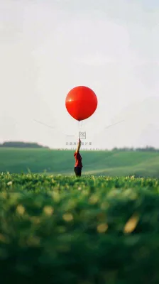 草地天空中的红色气球愚人节摄影图