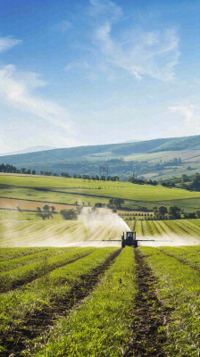 农田庄稼里耕种的机器农忙劳动节摄影图