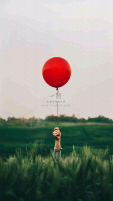 草地天空中的红色气球愚人节摄影图