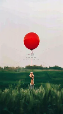 草地天空中的红色气球愚人节摄影图