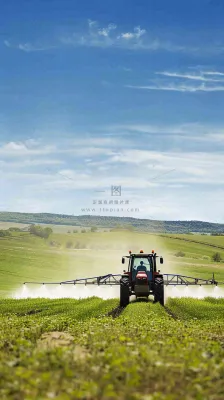 农田庄稼里耕种的机器农忙劳动节摄影图