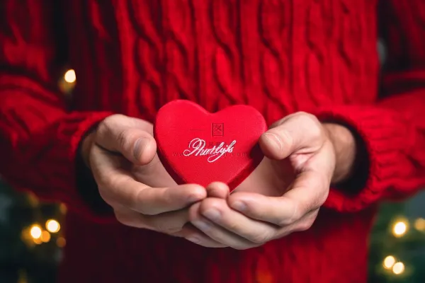 男孩手捧红色爱心礼盒摄影图